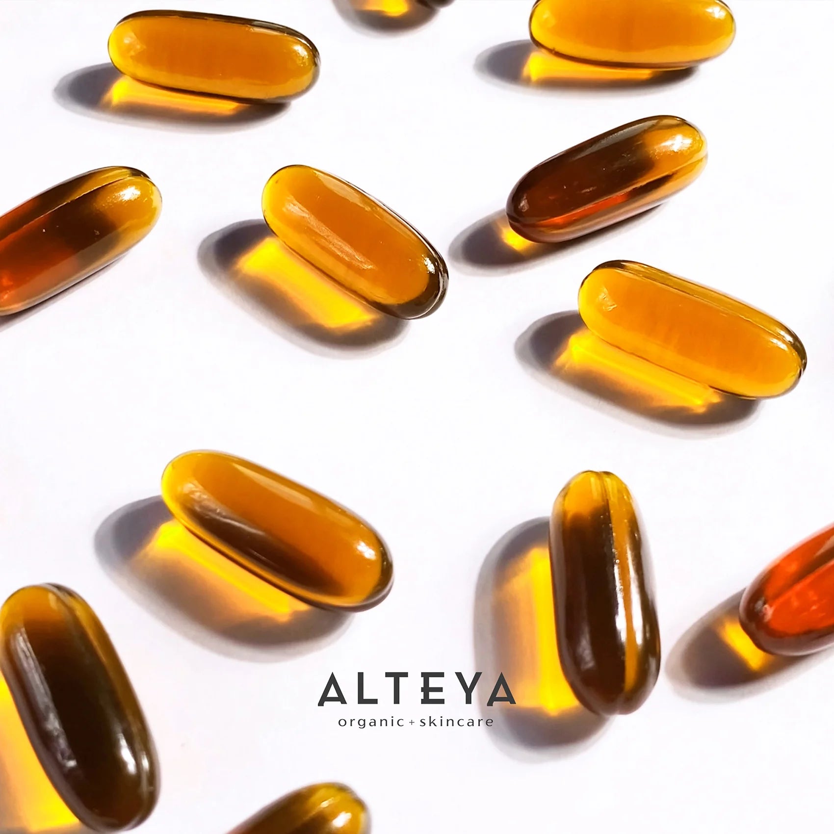 A group of Rose Beauty Omegas Skin & Hair Organic Supplement capsules on a white surface.