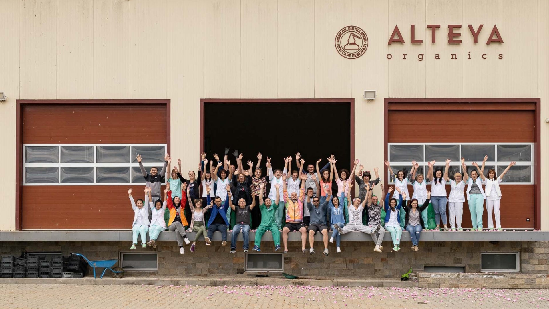 A group of people standing in front of a building, surrounded by the exquisite fragrance of Bulgarian rose.