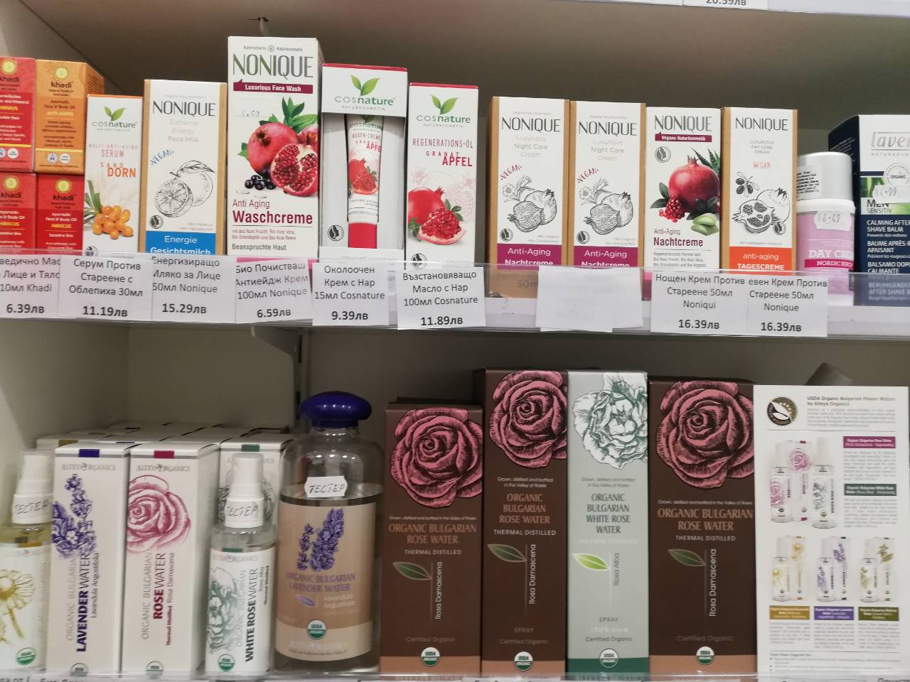A shelf full of cosmetic products featuring rosa damascena and alteya extracts in a store.