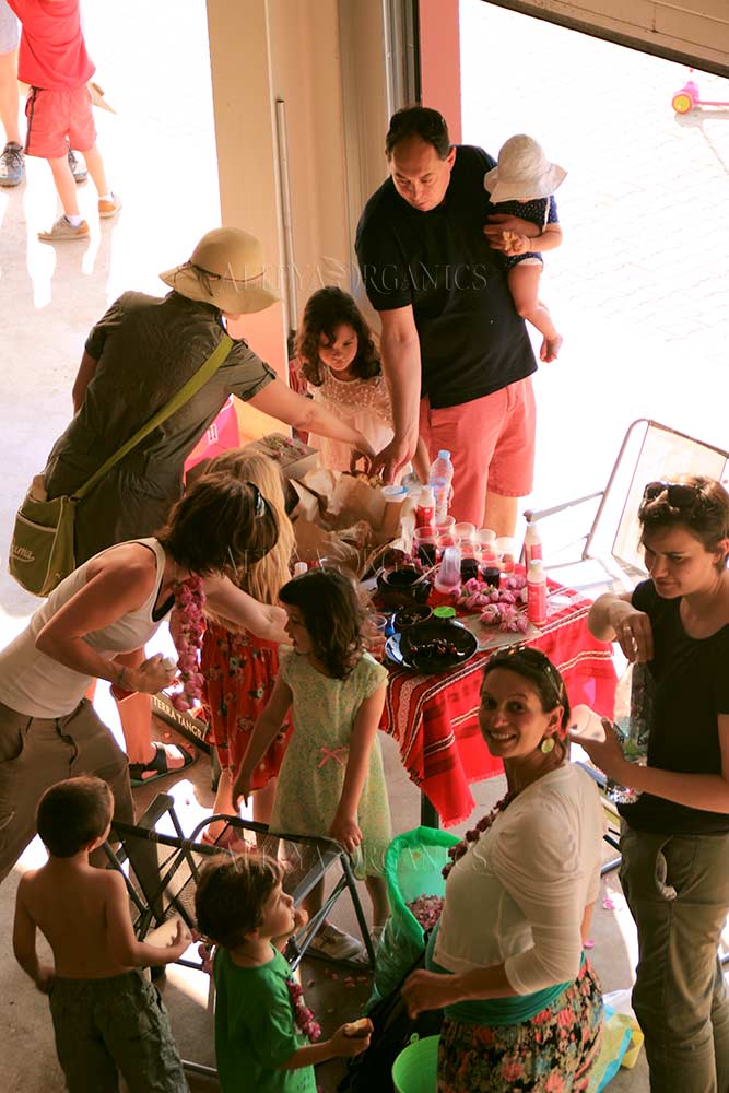 A group of people standing around a table adorned with beautiful Rosa Damascena flowers.