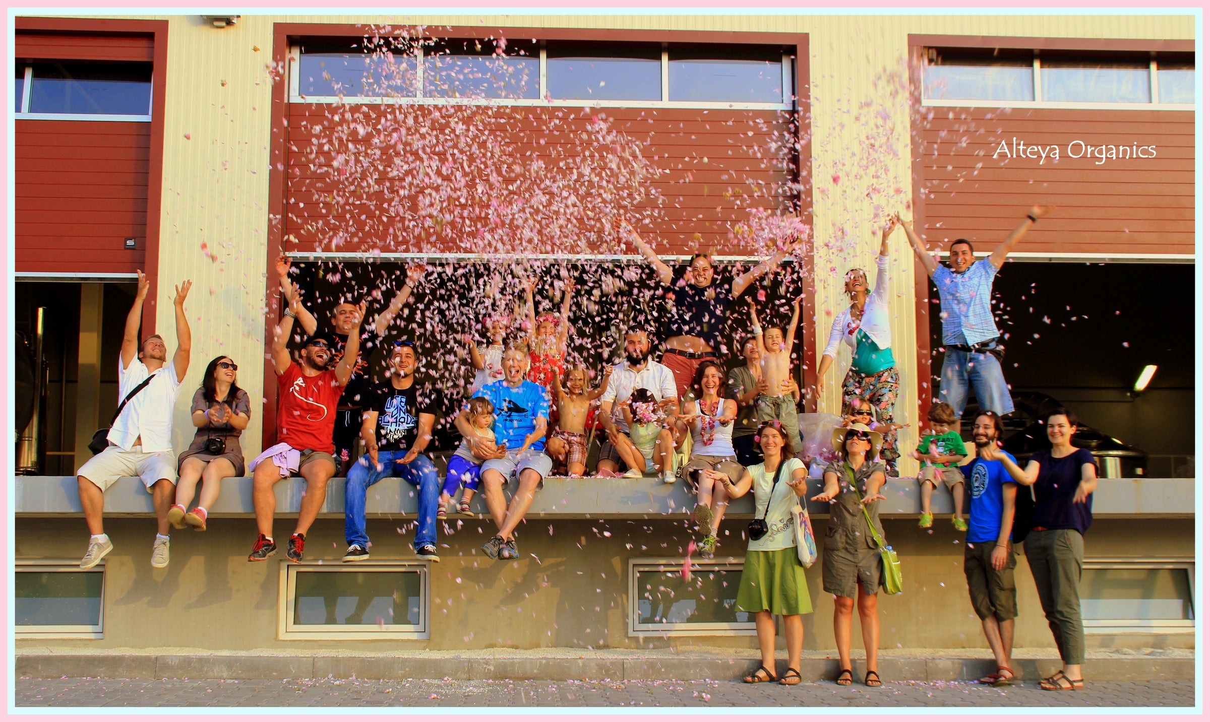 A group of people posing in front of a building surrounded by rose fields (Alteya) filled with Rosa Damascena.