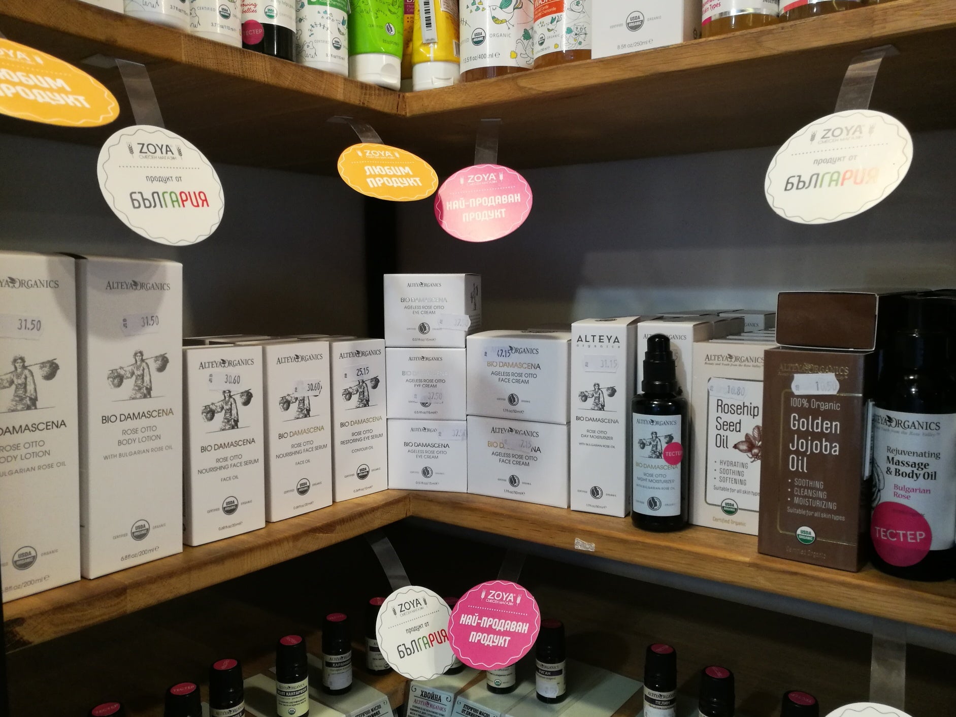 The shelves of a store are filled with different types of products, including Alteya's Rosa Damascena from their Rose Fields collection.
