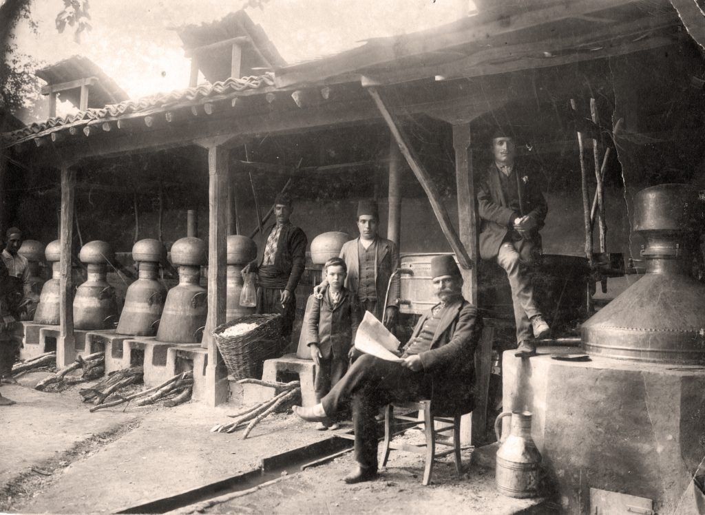A group of men standing outside of a building, surrounded by the enchanting scent of Bulgarian rose (Rosa damascena).