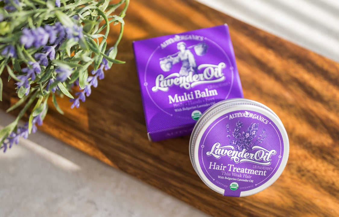 A tin of Bulgarian rose lavender body butter on a wooden cutting board.